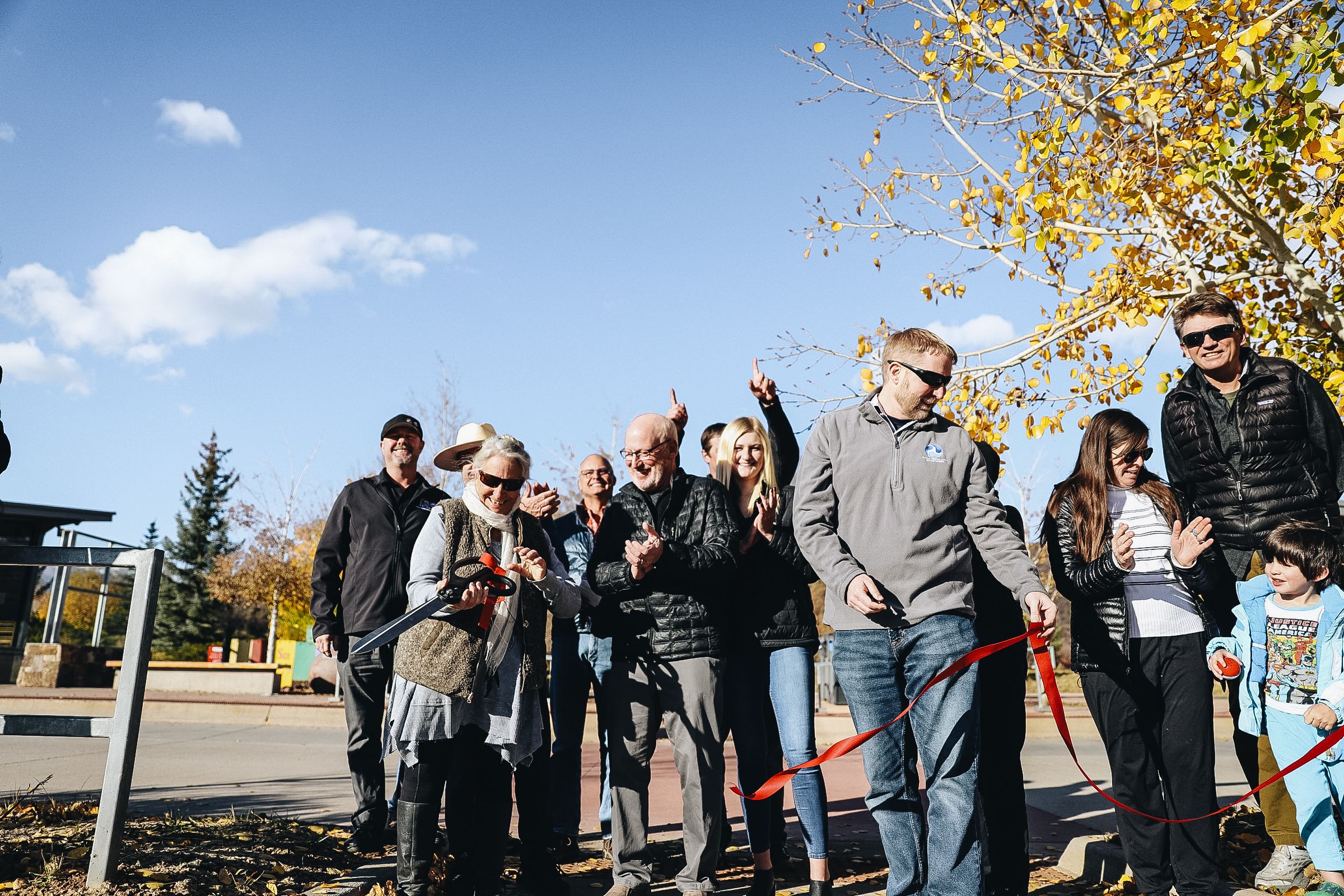 Elected leaders and other government officials cut a ribbon at a newly renovated Intercept Lot.