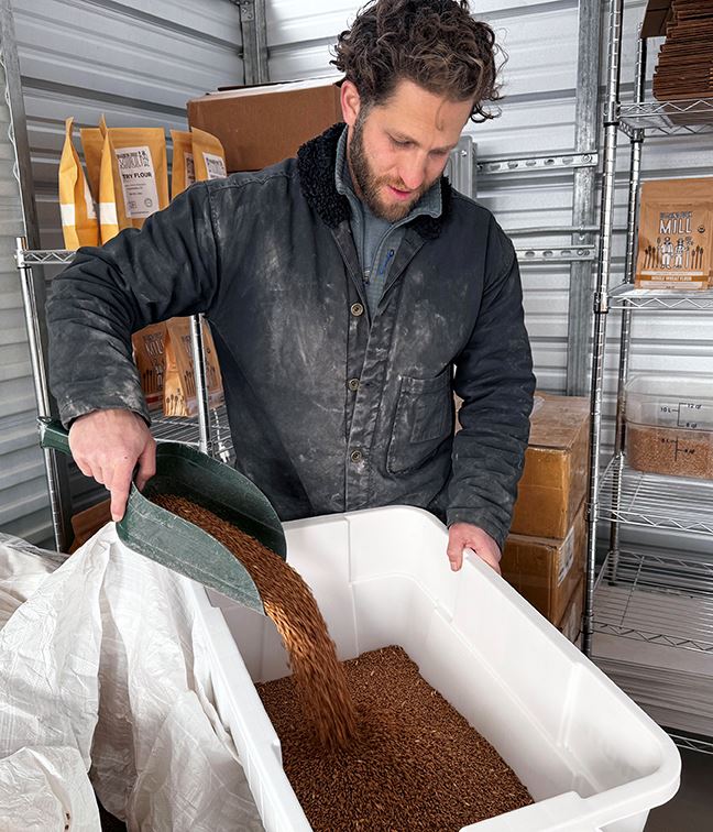 Jacob Trumbull prepares to grind locally grown wheat into flour