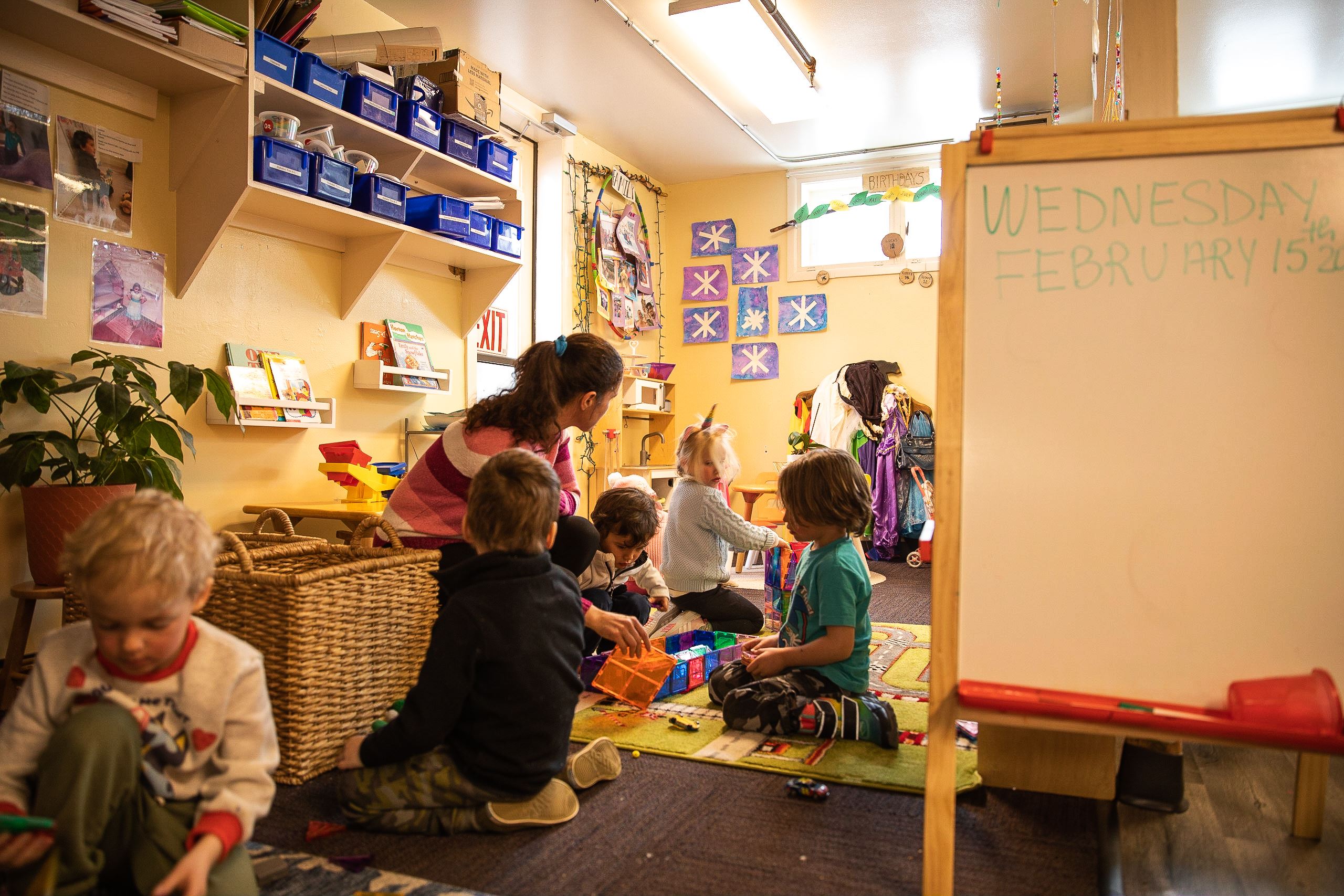 Kids play and handle toys inside the Little Red Schoolhouse